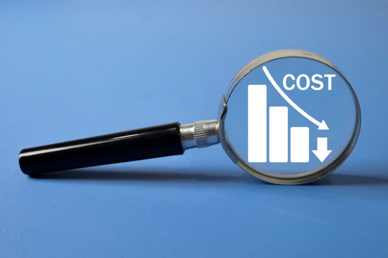 コスト削減を示すグラフに焦点を当てている虫眼鏡。